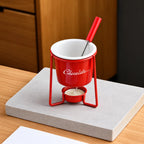 Red ceramic chocolate fondue bowl on a metal stand with tealight and dipping fork